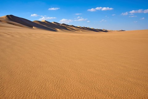 Wide desert landscape with gentle sand dunes under a blue sky with scattered clouds, Matruh, Great