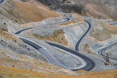 Winding roads on the Pamir Highway, mountain road through an eroded mountain landscape, Kyrgyzstan,