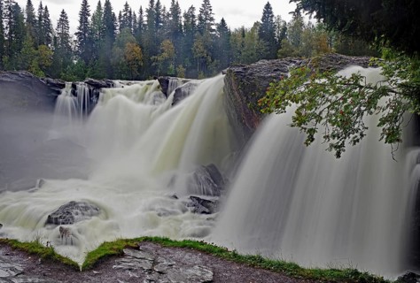 A rushing waterfall in a forest, shrouded in fine mist, autumn, Ristafallet, jämtland, Sweden,