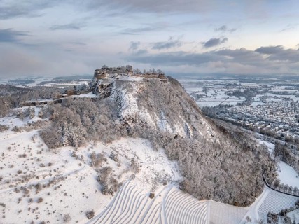 Aerial view of the snow-covered Hegau volcano Hohentwiel with Germany's largest castle ruin on a