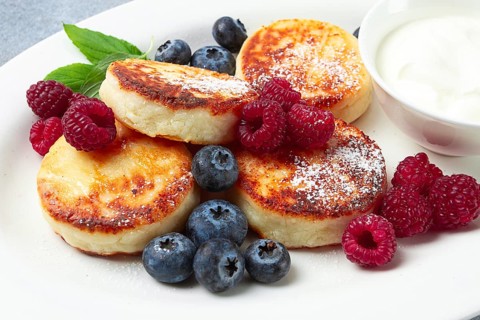 Breakfast, cottage cheese cakes, with fresh berries, and sour cream, top view, close-up, no people
