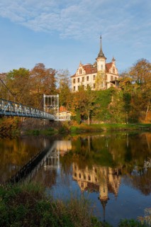 Castle on a hill with reflection in the river, connected with a bridge in autumn light, Gattersburg