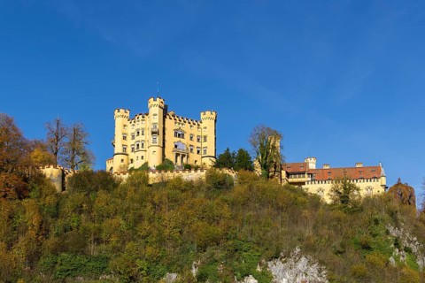 An impressive castle on a wooded hill with rocky ground, Hohenschwangau Castle, Schwangau,