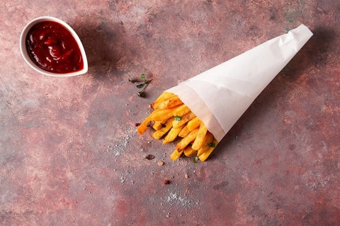Fried French fries, in a paper bag, on an abstract background, no people, rustic