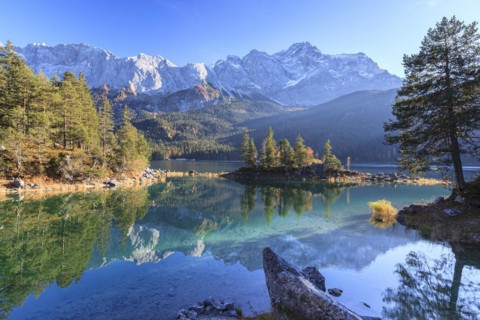Steep mountains reflected in lake, evening light, autumn, Eibsee lake, Zugspitze, Bavaria, Germany,