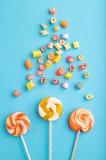 Various caramel candies on blue pastel background. close up, top view, flat lay