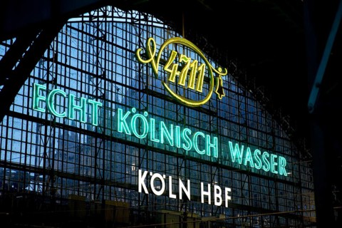 Illuminated advert for 4711, Echt Kölnisch Wasser at Cologne Central Station in the evening,