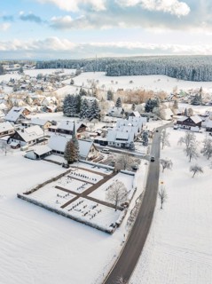 Snow-covered village with church and surrounding snow-covered buildings, Oberreichenbach, Black