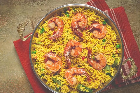 Rice with saffron and shrimp, in a frying pan, paella with shrimp, top view, homemade, no people