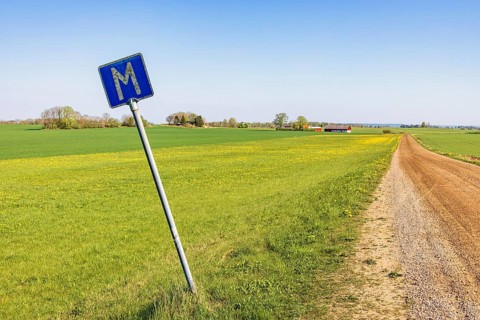Meeting point road sign at a dirt road in the countryside a sunny day at springtime, Sweden, Europe