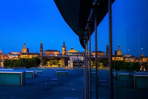Reflection of the illuminated Old Town of Dresden in the façade of the Dresden Congress Centre