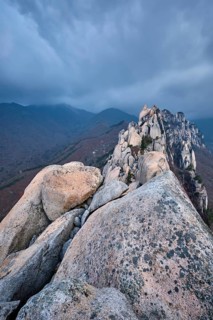 View of stones and rock formations from Ulsanbawi rock peak in stormy weather with clouds.