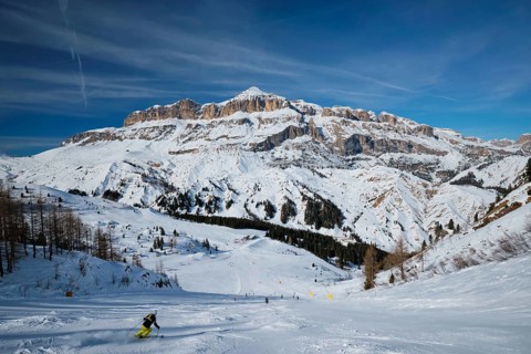 View of a ski resort piste with people skiing in Dolomites in Italy. Ski area Arabba. Arabba,