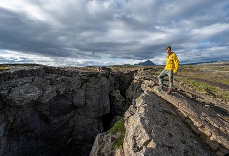 Tourist at a crevice, Grjótagjá, Myvatn, Iceland, Europe