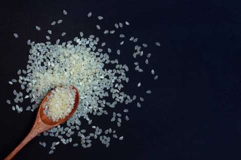Rice, white rice grains in wooden spoon