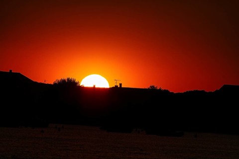 Red sunset behind house roofs, backlight, France, Europe