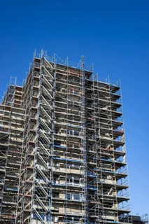 Scaffolded high-rise residential building with balconies and satellite dishes, Trabantenstadt