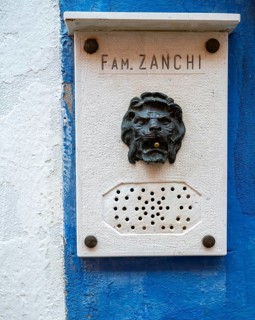 Name and doorbell button in the shape of a lion on a blue house wall, Burano Island, Venice,