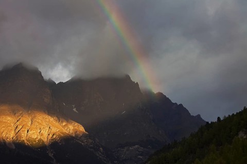 Rainbow over the mountains at Val Mingèr, Swiss National Park at Graubünden, Grisons in the Alps,