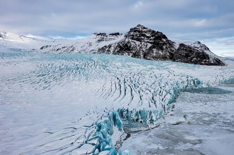 Snow-covered icebergs in the Fjallsarlon glacier lagoon, with the Öraefajökull glacier behind,