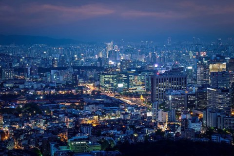 Seoul downtown cityscape illuminated with lights and Gyeongbokgung Palace in the evening view from