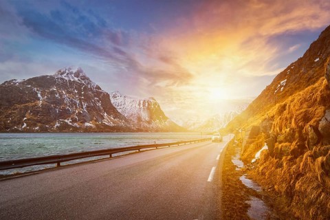 Car on road in Norwegian fjord on sunset. Lofoten islands, Norway, Europe