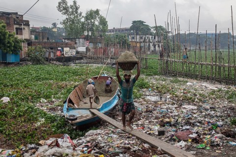 Construction workers transporting sand from a boat over a plank, Tel Ghat, Dhaka, Bangladesh, Asia