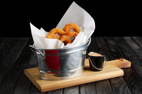 Snack for beer. Fried onion rings with sauce served in metal backet