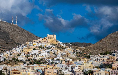 View of the town of Ermoupoli with pastel-coloured houses, on the hill Basilica of San Giorgio in