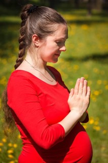 Pregnancy yoga exercise, pregnant woman doing asana Tadasana namaste -Mountain pose with salutation