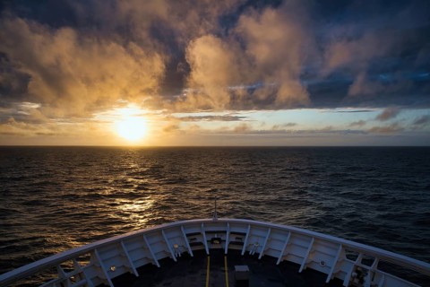 View from the ferry King Seaways of an atmospheric sunset with dramatic clouds over the North Sea,