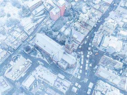 Drone image of a town covered in snow with visible streets and roofs, Black Forest, Calw, Germany,