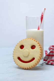 Pastry with smiley face and glass of milk