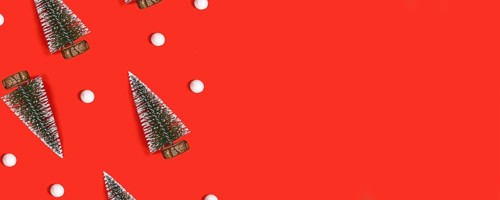 Red Christmas banner with trees and snowballs on red background with copy space