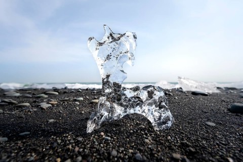 Ice, piece of ice on black sand beach, on black lava beach Diamond Beach, Southeast Iceland,