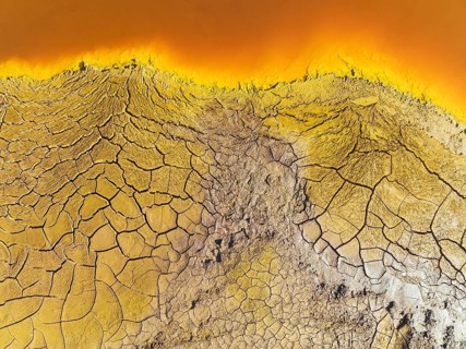 Cracked earth at the bank of the Rio Tinto (Red river) with its deep reddish hue due to oxidised