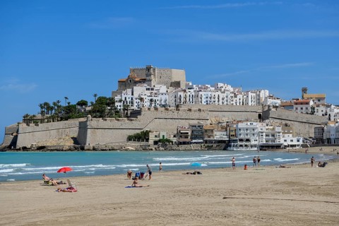 Bathers at the Playa de Peñíscola, beach, against the backdrop of the old town, Peñíscola, province