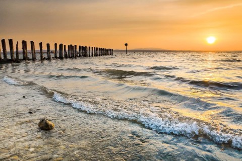 Golden sunrise on the shore of Lake Constance with jetty near Altnau in the canton of Thurgau,