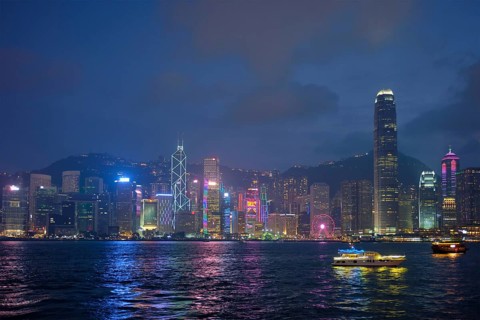 Hong Kong skyline cityscape downtown skyscrapers over Victoria Harbour in the evening illuminated