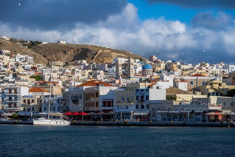 View of the town of Ermoupoli with pastel-coloured houses and sea, waterfront promenade with