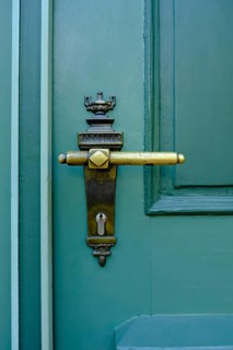 Old historical door handle on a green door