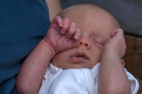 Infant rubbing his eye with his hand, Mecklenburg-Vorpommern, Germany, Europe