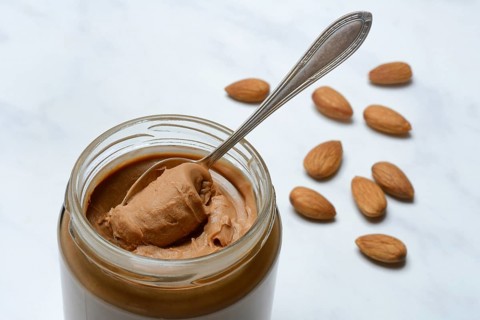 Almond cream in jar with spoon, almond spread