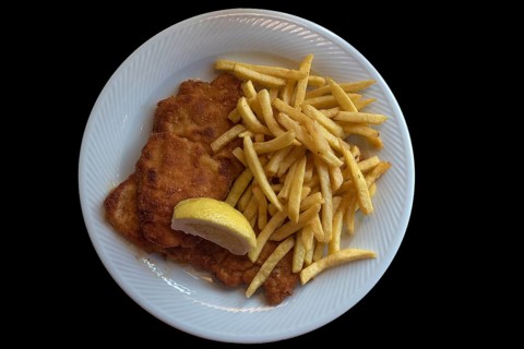 Wiener Schnitzel with french fries on a black background, Franconia, Bavaria, Germany, Europe