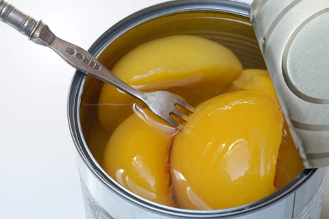 Peach, preserved peach halves with syrup in a tin can