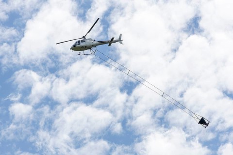 Helicopter, helicopter with container for applying a soil protection liming, forest liming,