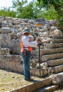 Surveyor at work, Temple of Panels, Templo de los Tableros Esculpidos, Chichen Itzá, Mayan ruins,