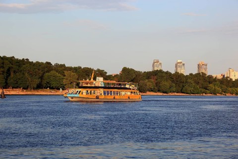 Excursion boat on the river Dnepr and skyscrapers in the background, Kiev, Ukraine, Europe
