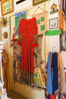 Red dress, ties and paintings for sale inside second hand goods and chattels store, Quebec, Canada,