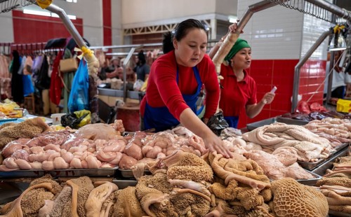 Woman selling meat and entrails, butcher's shop with fresh meat, market at Osh bazaar, Bishkek,